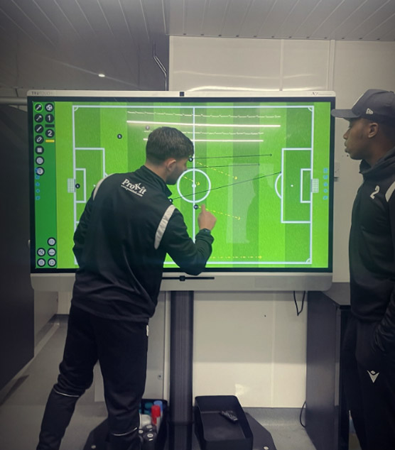 Esports analysts reviewing a replay on a tactical map and drawing player movements to explain a rotation